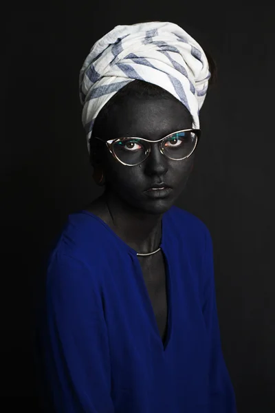 Retrato fotográfico de una niña en una blusa de turbante y gafas de sol pintado de color gris oscuro de la piel — Foto de Stock