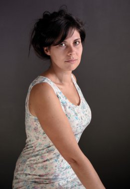 gri bir arka plan üzerinde beyaz çiçek elbise koyu saçlı kızlardan fotoğraf portre