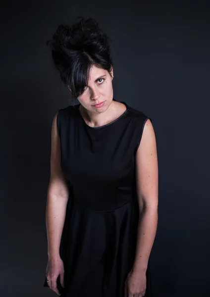 Foto caprichosa mujer en un vestido negro con un alto peinado manos abajo — Foto de Stock