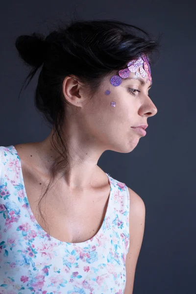 Retrato fotográfico de una chica morena en vestido floral blanco con lentejuelas en su perfil de frente — Foto de Stock