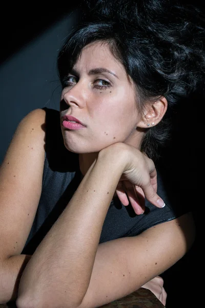 Foto retrato de una mujer de negro con el pelo alto se apoya en sus codos — Foto de Stock