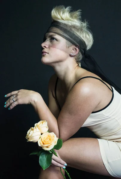 Φωτογραφία ξανθιά κοπέλα σε ένα μπεζ φόρεμα Διάφανο Μαύρο blindfold ποζάρει με τριαντάφυλλα — Φωτογραφία Αρχείου