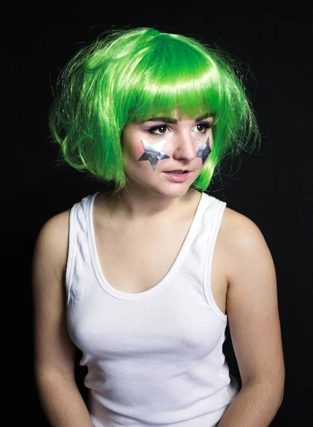 Foto menina em uma peruca verde e estrelas em suas bochechas — Fotografia de Stock