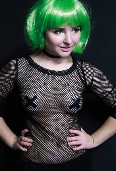 Πορτρέτο ενός κοριτσιού σε μια πράσινη περούκα και ένα φόρεμα φτιαγμένο από διαφανές πλέγμα με μαγνητοσκοπημένο θηλές με μαύρη ταινία — Φωτογραφία Αρχείου