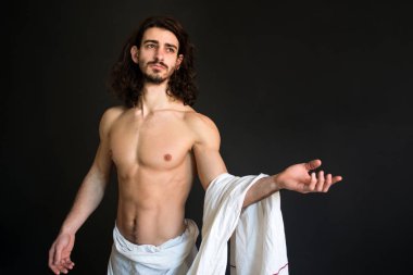 Beyaz bir perdelik kıvırcık saçlı güzel yarı çıplak adam fotoğraf