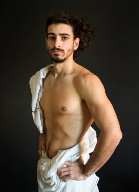 Beyaz bir perdelik kıvırcık saçlı güzel yarı çıplak, sakallı adam fotoğraf