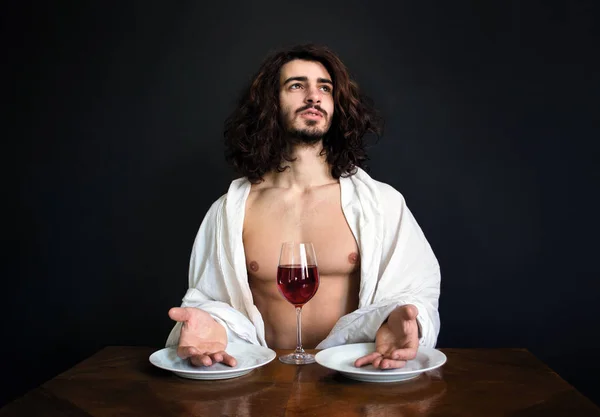 Foto chico con pelo largo rizado blanco cortinas y dos platos vacíos y con vaso de vino tinto mirando hacia arriba — Foto de Stock