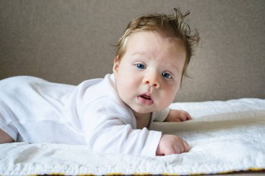 Beyaz giysiler portre fotoğraf sarışın bebek yatıyor