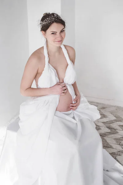 Foto Chica Embarazada Una Diadema Una Cortina Blanca Sobre Fondo —  Fotos de Stock