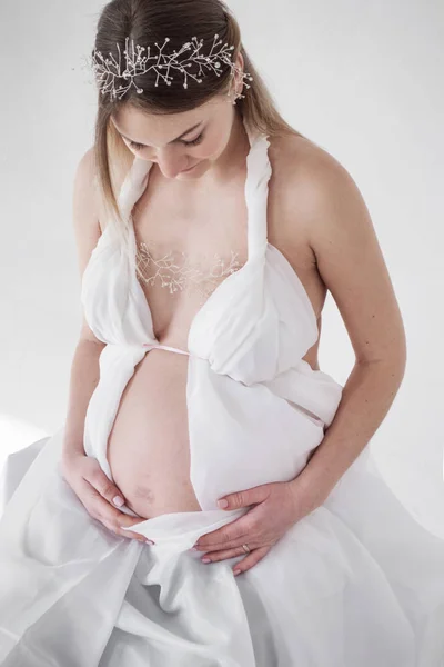 Foto Chica Embarazada Ropa Blanca Sobre Fondo Blanco Manos Estómago —  Fotos de Stock