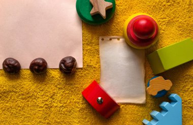 Kağıt ve farklı nesneler içeren renkli oyuncaklar için metin kompozisyonu oluşturmak için fotoğraf üst görünüm sarı Terry arkaplan