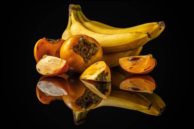 Siyah bir ayna yüzeyinde muz ve hurma dolu bir hayat