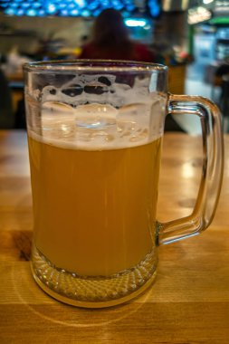 Bir bardaki masada, dökme demir tavada ızgara sosis, sığ bir tarla derinliği.