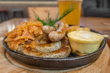 grill sausages on a cast iron skillet on a table in a pub