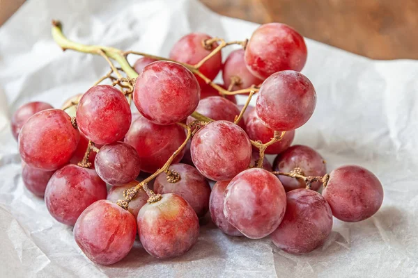 Rama Jugosas Uvas Rosadas Dulces Pergamino Sobre Una Mesa Madera — Foto de Stock