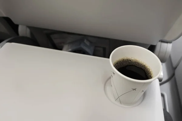 Taza de café café negro en avión. Beber en el avión . — Foto de Stock