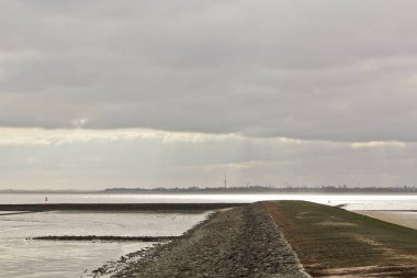 Almanya 'nın Aşağı Saksonya bölgesindeki Butjardingen' de su, bulut, hendek ve deniz kabukları.
