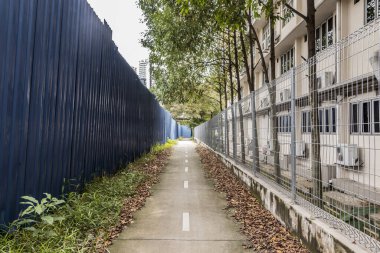 Kuala Lumpur, Malezya 'daki inşaat alanlarıyla sınırlar arasında yürü. Mavi duvarlar ve çitler.