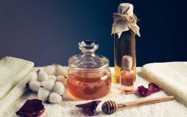 Tatlım, bir şişe yağ ve bir şişe pembe su beyaz havluda, spa tedavileri için..