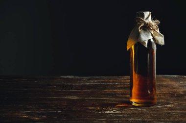 Ahşap bir masada yağlı bir şişe..