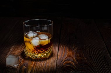 Tahta masada buzlu bir bardak viski.