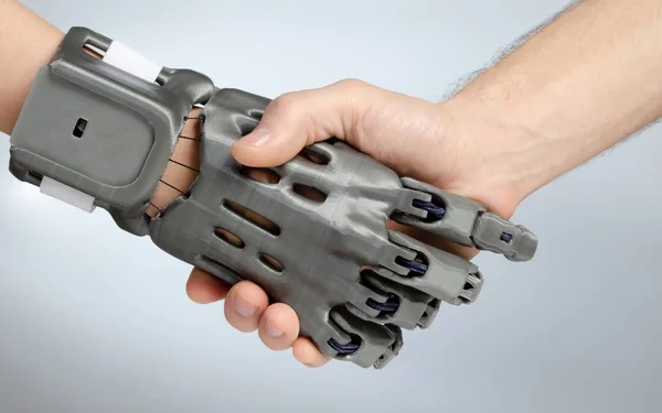 Hand with prosthesis printed on FDM 3D printer, handshake of the prosthesis and a healthy hand on an isolated background. — Stock Photo, Image