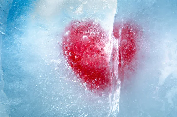 Corazón rojo congelado en hielo con una gran grieta, un símbolo de amor o traición o separación — Foto de Stock