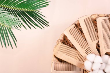 Üzerinde tropikal yapraklar olan hasır sepetin içindeki ahşaptan yapılmış çevre dostu taraklar..