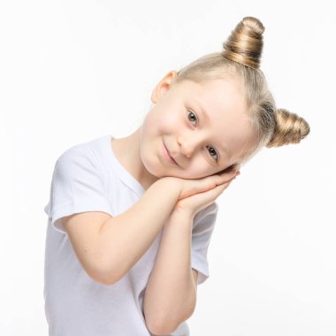 Beyaz tişörtlü küçük sarışın bir kız ellerini başının altına katladı. Uyuma isteği ya da şefkat kavramı.