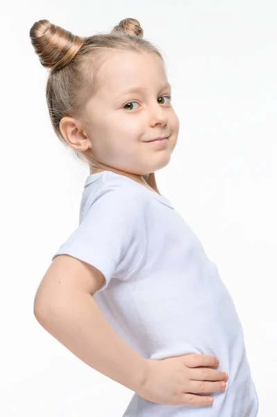 髪の角を持つ白いTシャツの女の子が横に立って彼女の手で彼女のベルト. — ストック写真