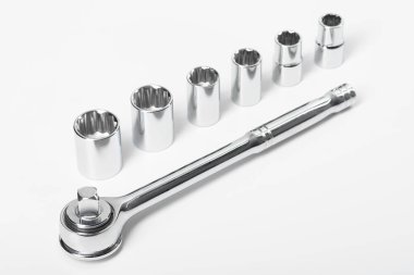 Beyaz izole bir arka planda, cırcırlı ve kafalı krom anahtar..