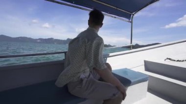 Bir Teknede Oturan ve Dünyanın Güzelliğini İzleyen Genç Adam, Langkawi Adası, Malezya 'daki Yatta Erkek. Konsept: Solo Seyahat, Yeni Deneyim, Macera, Yavaş Hareket.