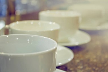 Masada ve kafenin arkasında bir sürü beyaz kahve fincanı var..