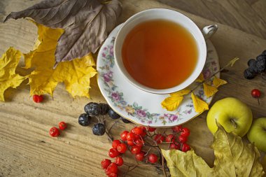 Sonbahar çayı. Rowanberry ve güz yapraklı bir fincan çay, göğüs.