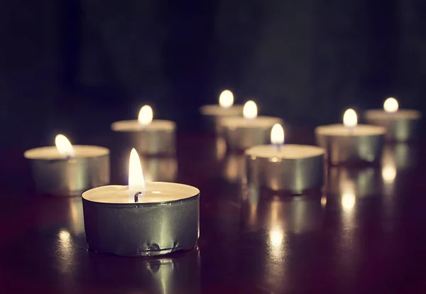 Candles lights on dark background. Light of candle flame, holida