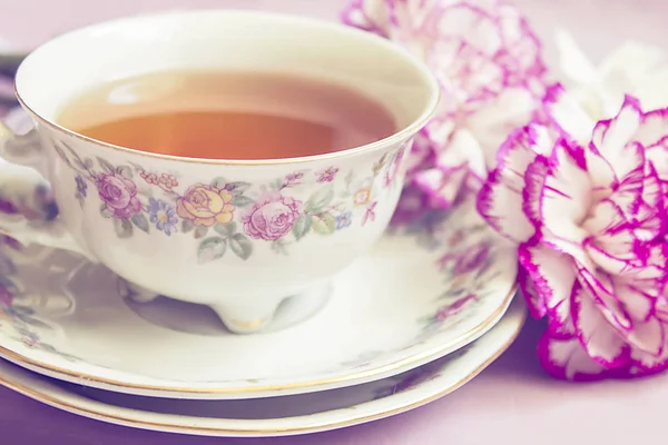 Vintage cup of  tea with pink  blooming  carnation, retro backgr — Stock Photo, Image