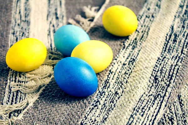 Κίτρινα και μπλε πασχαλινά αυγά σε φόντο χαλιών. — Φωτογραφία Αρχείου