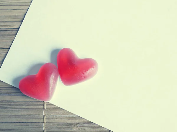 Dois corações de geleia vermelha no tapete fundo natural, papel branco com — Fotografia de Stock