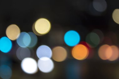 Bokeh ve şehrin sokaklarında odaklı olmayan ışıklarla soyut bir arkaplan.
