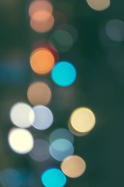 Bokeh ve şehrin sokaklarında odaklı olmayan ışıklarla soyut bir arkaplan.