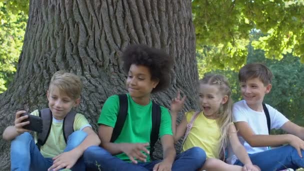Счастливые дети позируют селфи, показывая рок-жест, фотографирующийся со смартфоном — стоковое видео