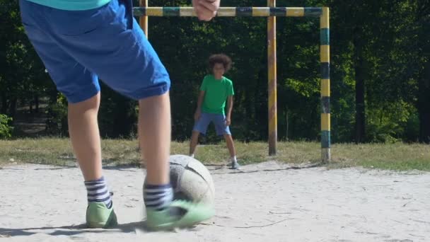 Hombre adolescente patadas fútbol, portero que falta pelota, competencia callejera — Vídeo de stock