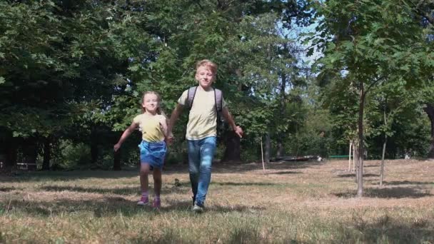 Feliz meninos e meninas da escola correndo ao ar livre de mãos dadas, câmera lenta — Vídeo de Stock