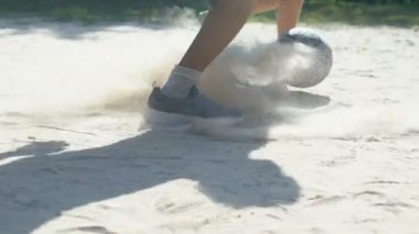 Okul çocukları tozlu zeminde futbol oynuyor, sokak oyunu oynuyor, yaz sporu yapıyor.