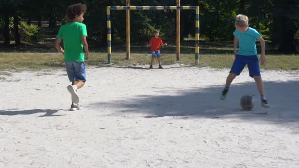 Barn som spelar fotboll utomhus, målvakt slår boll, sommaraktivitet — Stockvideo