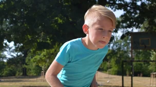 Konzentrierte kaukasische Junge läuft Sportplatz kicken Ball im Freien, Wettbewerb — Stockvideo