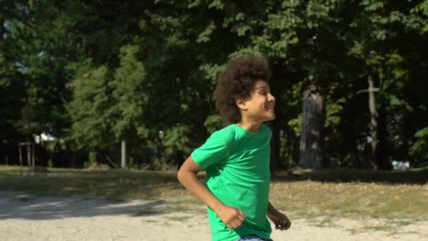 兴奋的非洲少年表现出肯定的姿态，跑步公园，赢得了比赛 — 图库视频影像