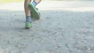 Sahada futbol oynayan aktif çocuk, spor hobisi, aktif dinlenme, yavaş çekim.