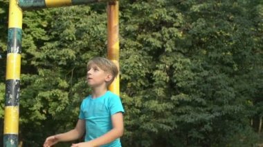 Erkek çocuk bahçede futbol oynamaya çalışıyor, yaz etkinliği