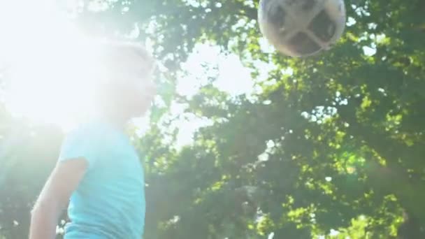 Jovem jogador qualificado chutando bola no playground praticando hit, câmera lenta — Vídeo de Stock